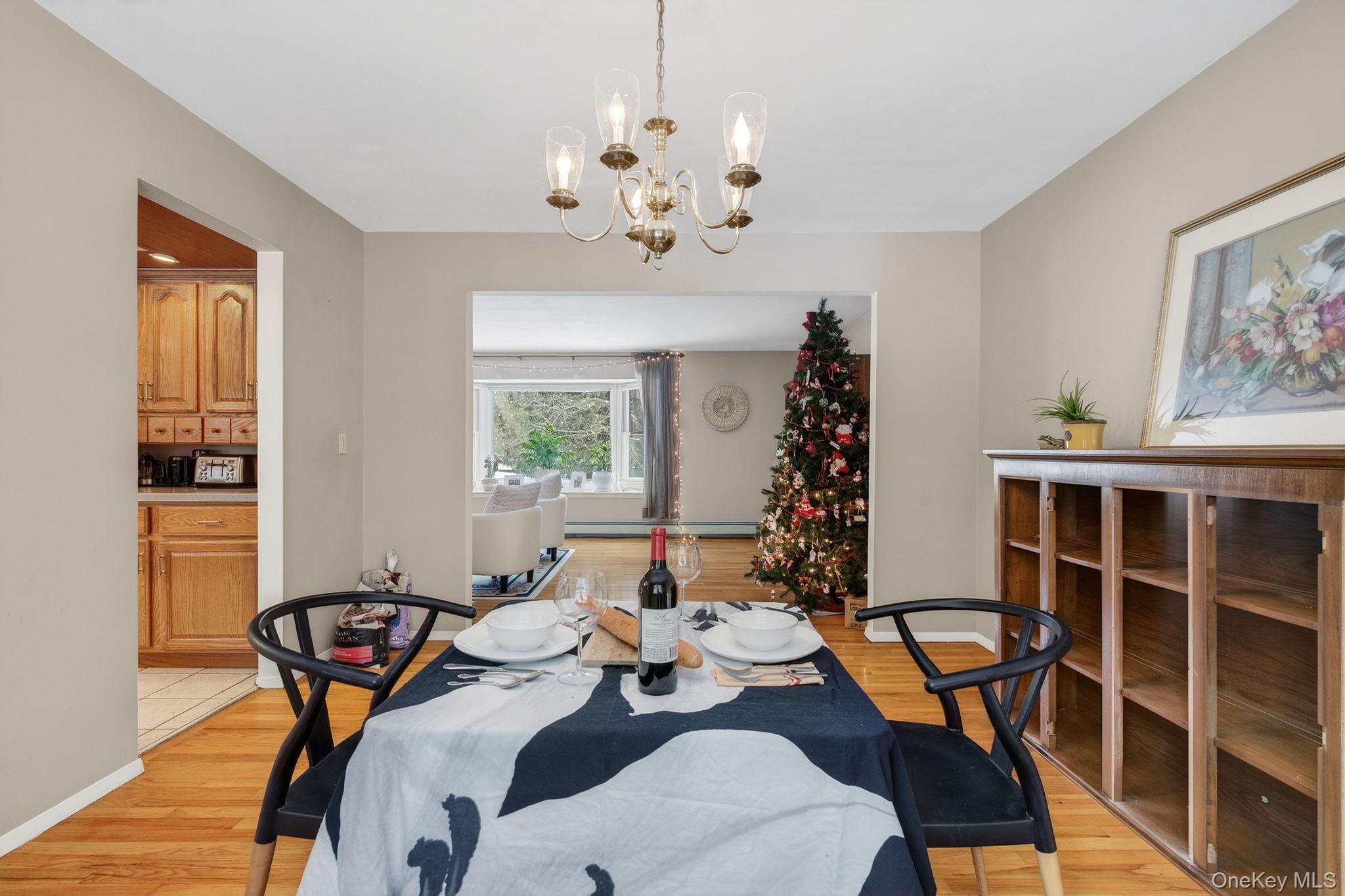 15 Royal Oak Road Stone Ridge, NY 12484 - Photo 8 of 34 Dining space featuring a chandelier, light wood-type flooring, and a baseboard radiator