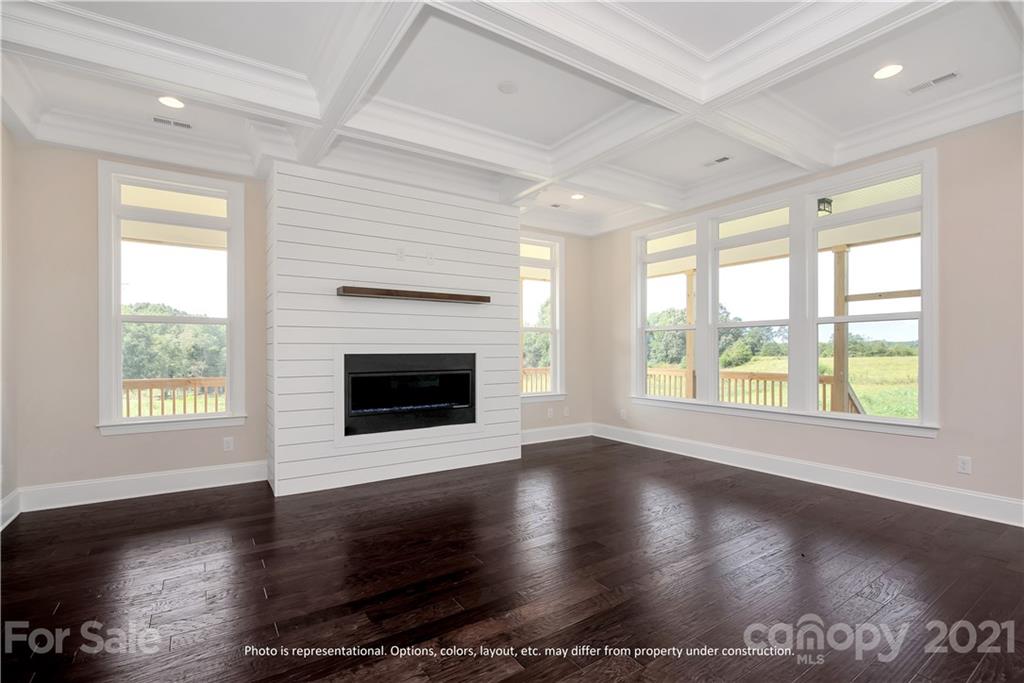 357 Grassy Rdg Court, Unit 50 Clover, SC 29710 - Photo 13 of 27 an empty room with wooden floor a fireplace and windows