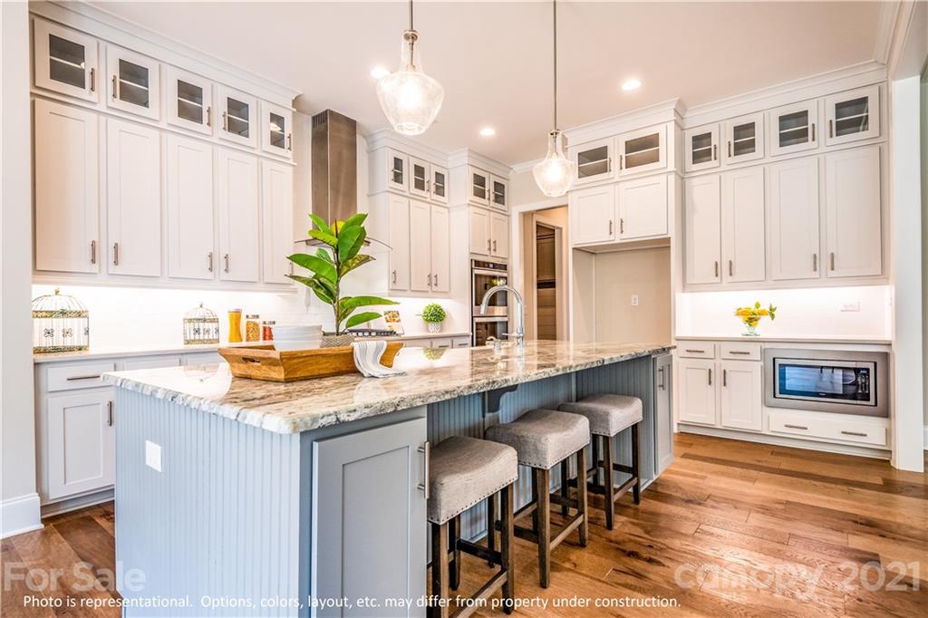 357 Grassy Rdg Court, Unit 50 Clover, SC 29710 - Photo 5 of 27 a kitchen with stainless steel appliances granite countertop a table chairs sink and cabinets