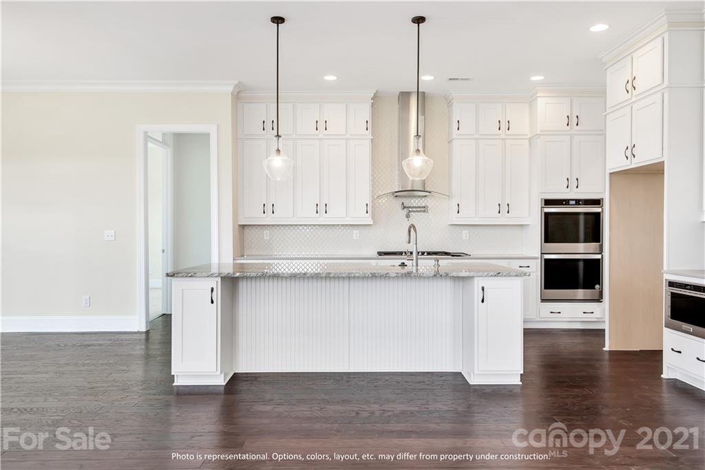 357 Grassy Rdg Court, Unit 50 Clover, SC 29710 - Photo 7 of 27 a kitchen with stainless steel appliances granite countertop a refrigerator a sink a stove and white cabinets with wooden floor