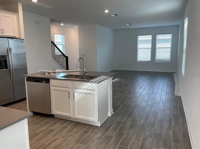 a kitchen with a sink window and stainless steel appliances