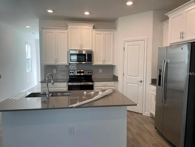 a kitchen with stainless steel appliances a refrigerator sink and stove