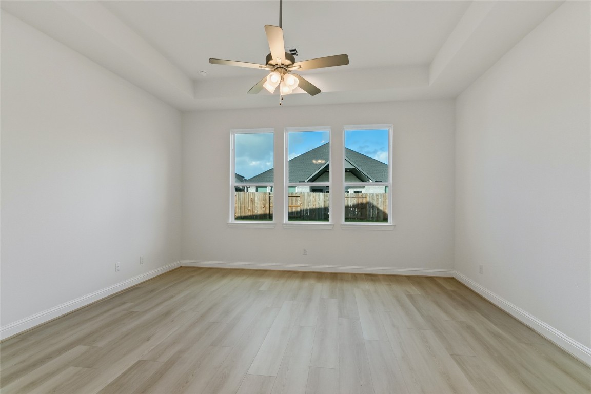 339 Afton June Drive Rosenberg, TX 77471 - Photo 24 of 44 an empty room with wooden floor chandelier fan and windows