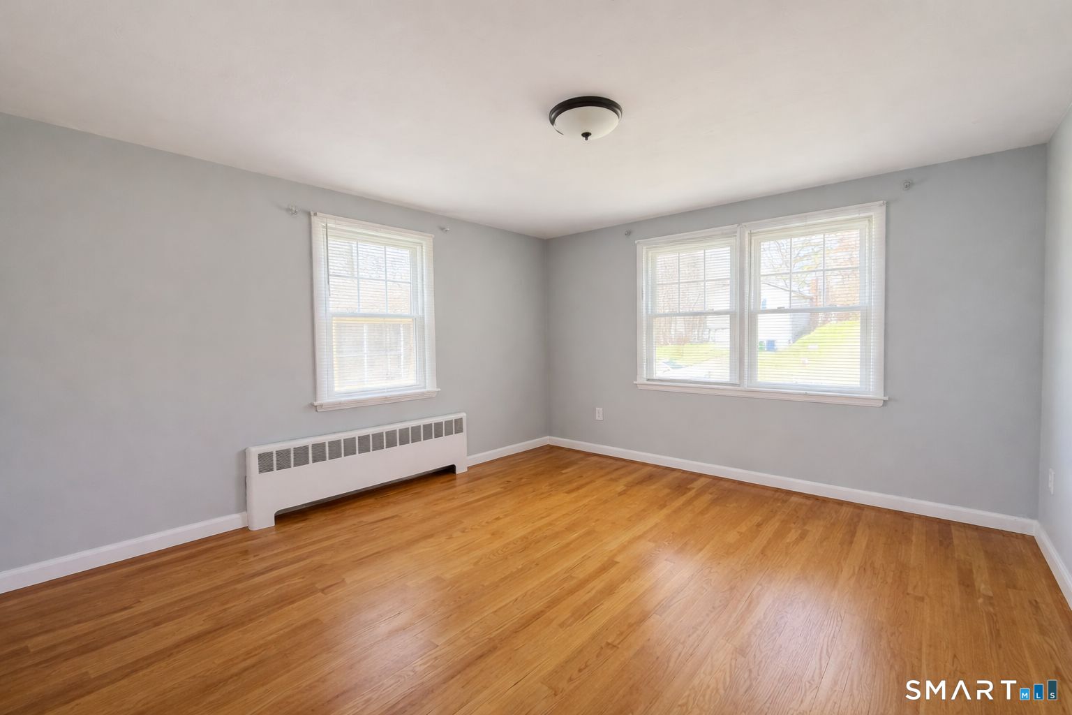 158 Colton Street Windsor, CT 06095 - Photo 4 of 15 an empty room with wooden floor and windows