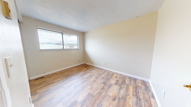1348 Sagewood Road Price, UT 84501 - Photo 18 of 34 Unfurnished room with wood finished floors and a textured ceiling