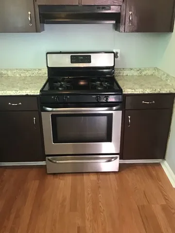 a stove top oven sitting inside of a kitchen