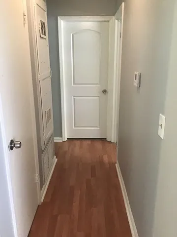 a view of a hallway with wooden floor and staircase