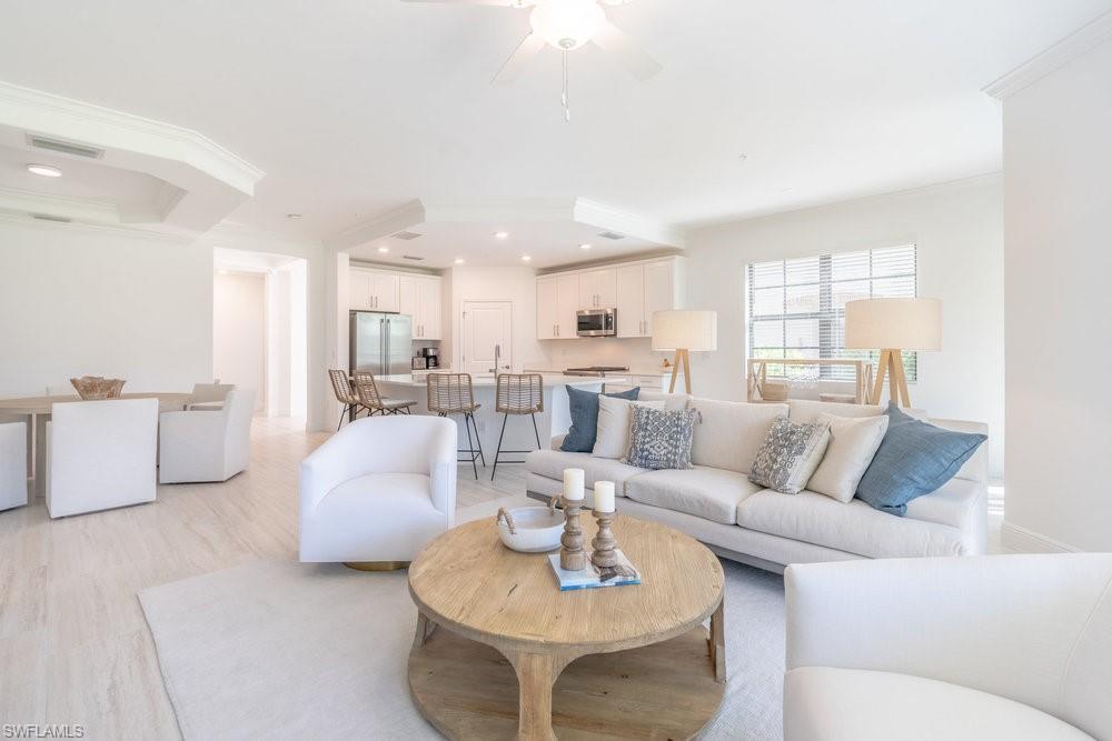 16352 Viansa Way, Unit 10101 Naples, FL 34110 - Photo 12 of 37 a living room with furniture and a large window