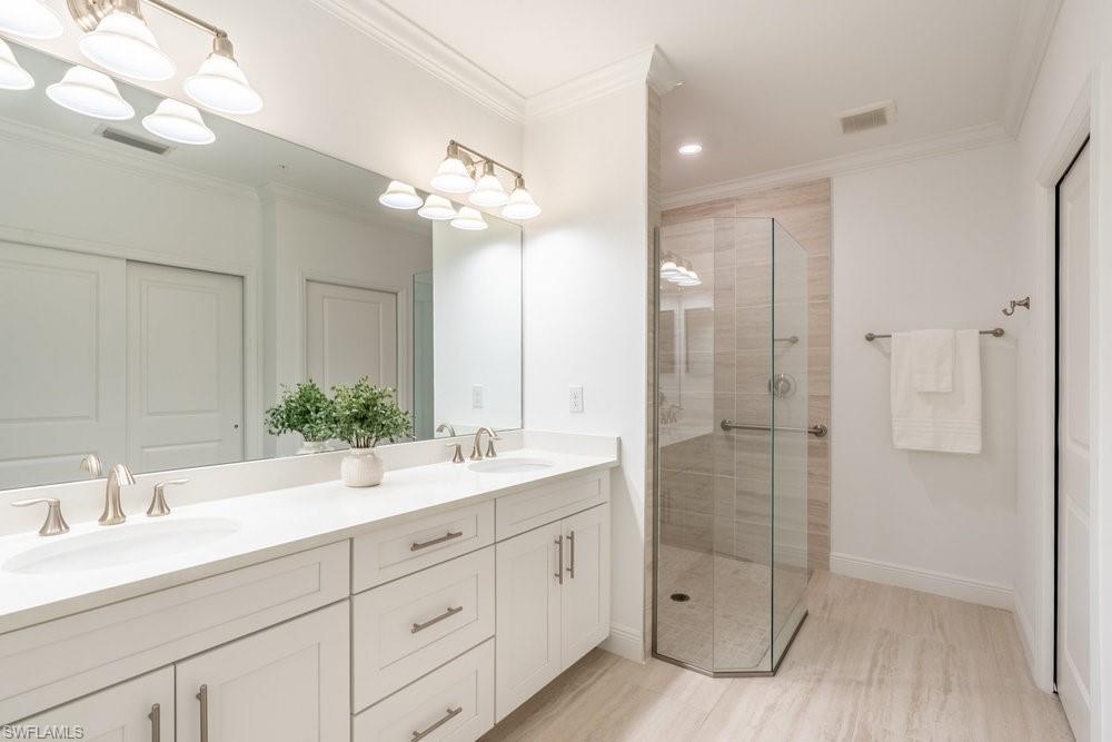 16352 Viansa Way, Unit 10101 Naples, FL 34110 - Photo 15 of 37 a bathroom with a double vanity sink mirror and shower