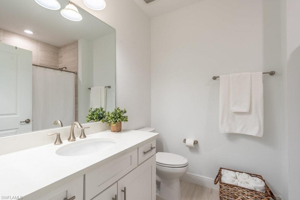 16352 Viansa Way, Unit 10101 Naples, FL 34110 - Photo 17 of 37 a bathroom with a sink vanity granite and toilet