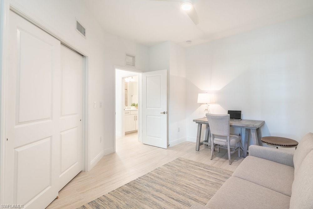 16352 Viansa Way, Unit 10101 Naples, FL 34110 - Photo 21 of 37 a living room with furniture and a wooden floor