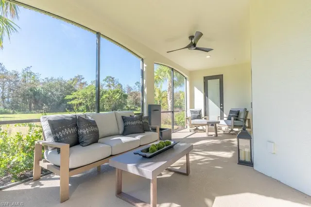 a living room with furniture and a floor to ceiling window