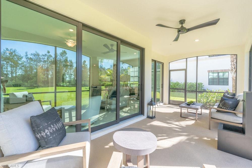 16352 Viansa Way, Unit 10101 Naples, FL 34110 - Photo 24 of 37 a living room with furniture and a floor to ceiling window