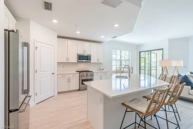 a kitchen with stainless steel appliances granite countertop a stove refrigerator sink and cabinets