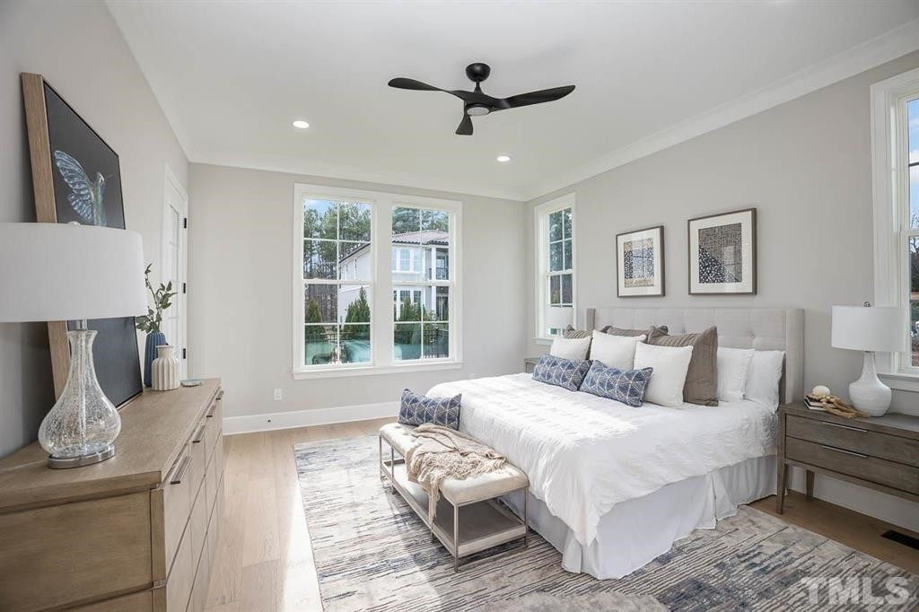 39 Treviso Place Durham, NC 27707 - Photo 9 of 18 a spacious bedroom with a bed a couch and a window