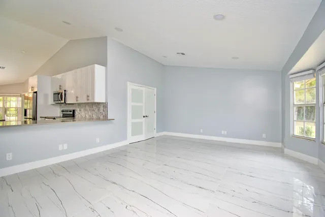 an empty room with a window and a ceiling fan
