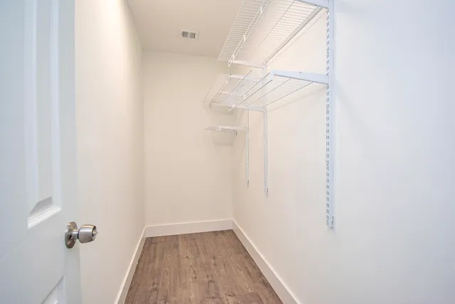 a view of a room with wooden floor and a ceiling fan