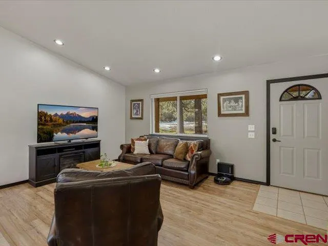 a view of a hallway with furniture and wooden floor