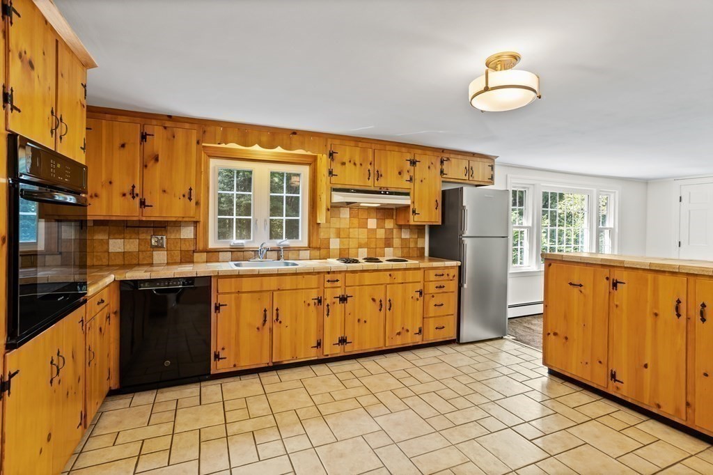 2 Jefferson Drive Acton, MA 01720 - Photo 14 of 38 a kitchen with granite countertop a stove a sink a window and dining table