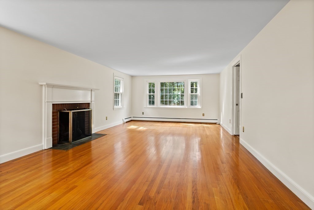 2 Jefferson Drive Acton, MA 01720 - Photo 6 of 38 an empty room with wooden floor and fireplace