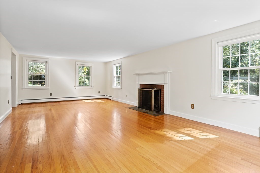 2 Jefferson Drive Acton, MA 01720 - Photo 7 of 38 a view of empty room with wooden floor and fireplace