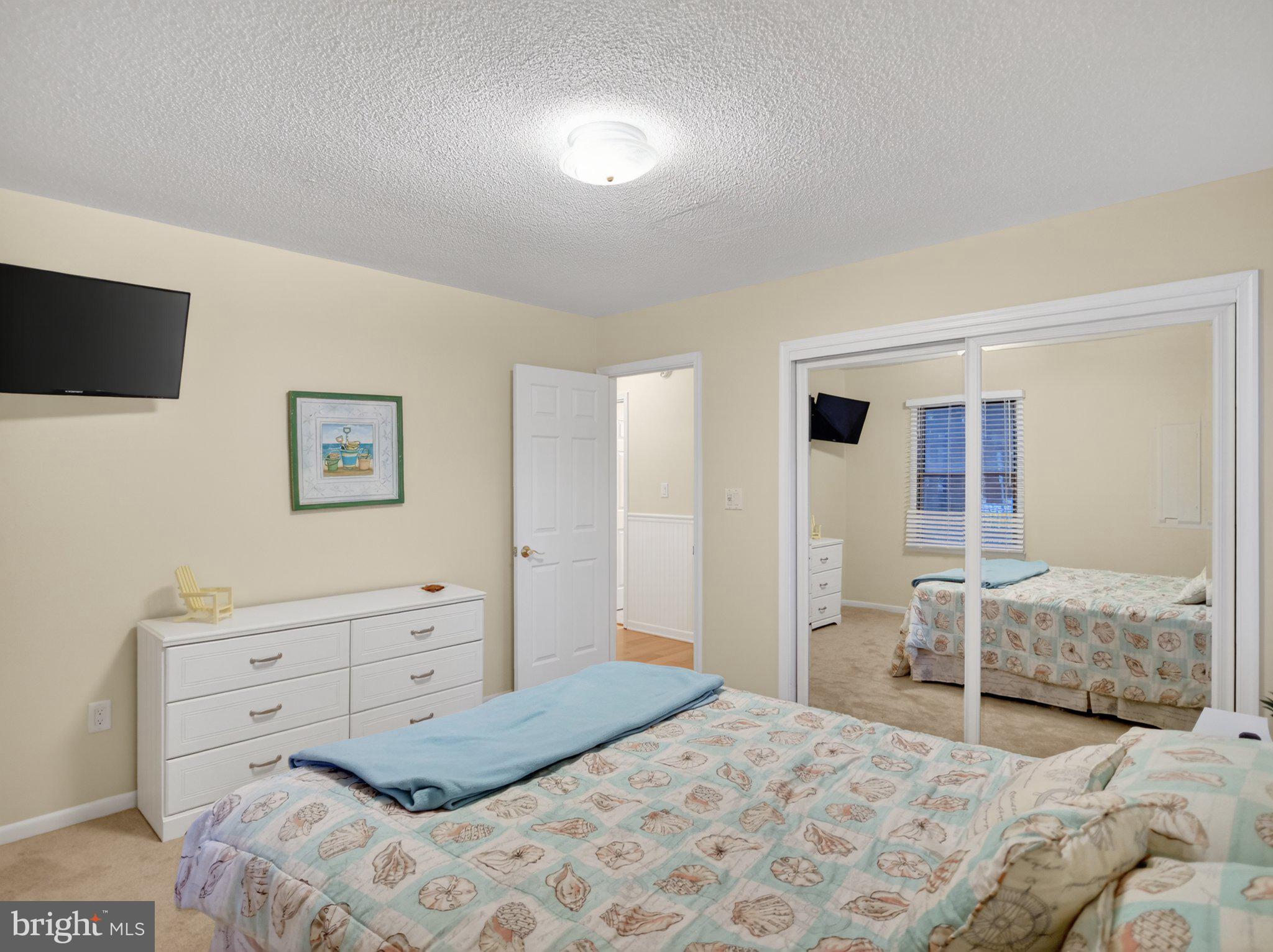 103 Channel Buoy Road Ocean City, MD 21842 - Photo 26 of 29 Serene bedroom with mirrored elegance.