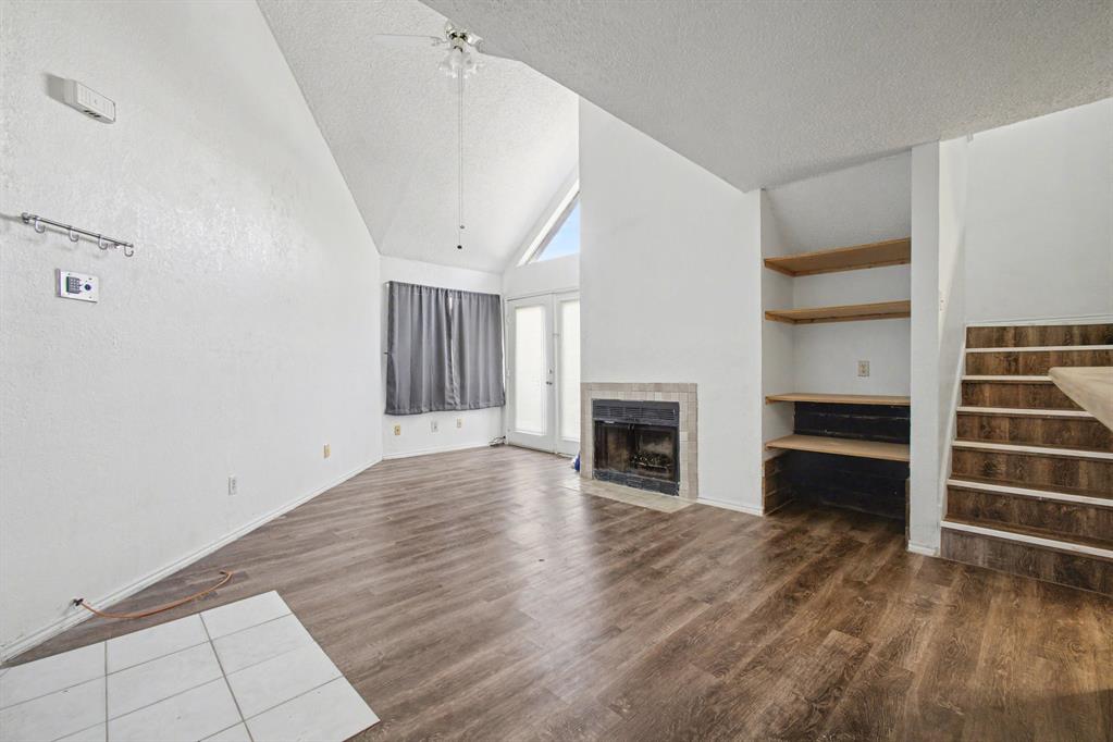 9827 Walnut Street, Unit 210 Dallas, TX 75243 - Photo 19 of 30 a view of a livingroom with a fireplace a ceiling fan and windows
