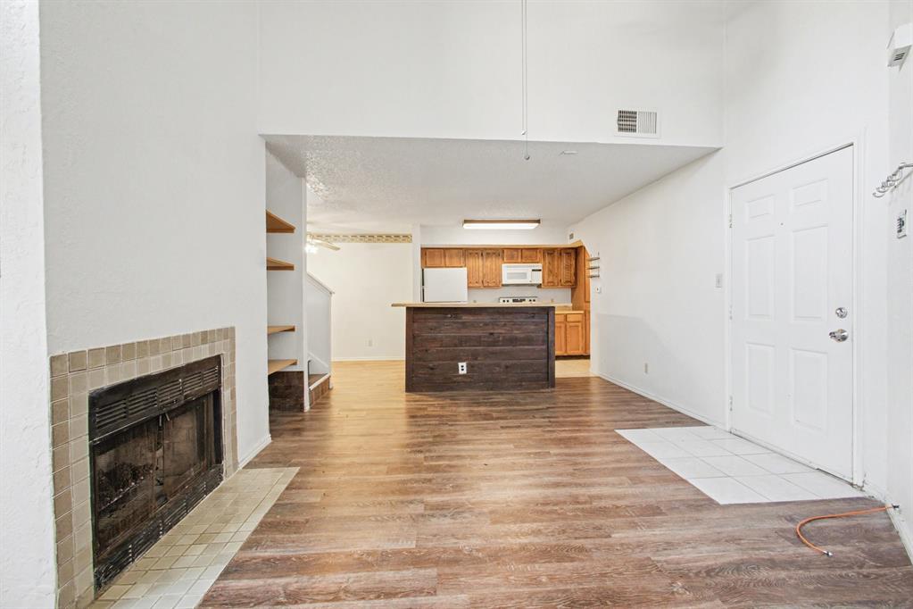 9827 Walnut Street, Unit 210 Dallas, TX 75243 - Photo 22 of 30 a view of empty room with wooden floor and fireplace