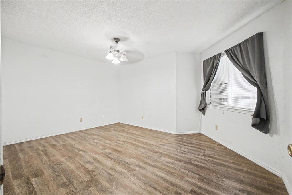 9827 Walnut Street, Unit 210 Dallas, TX 75243 - Photo 26 of 30 a view of empty room with wooden floor and fan