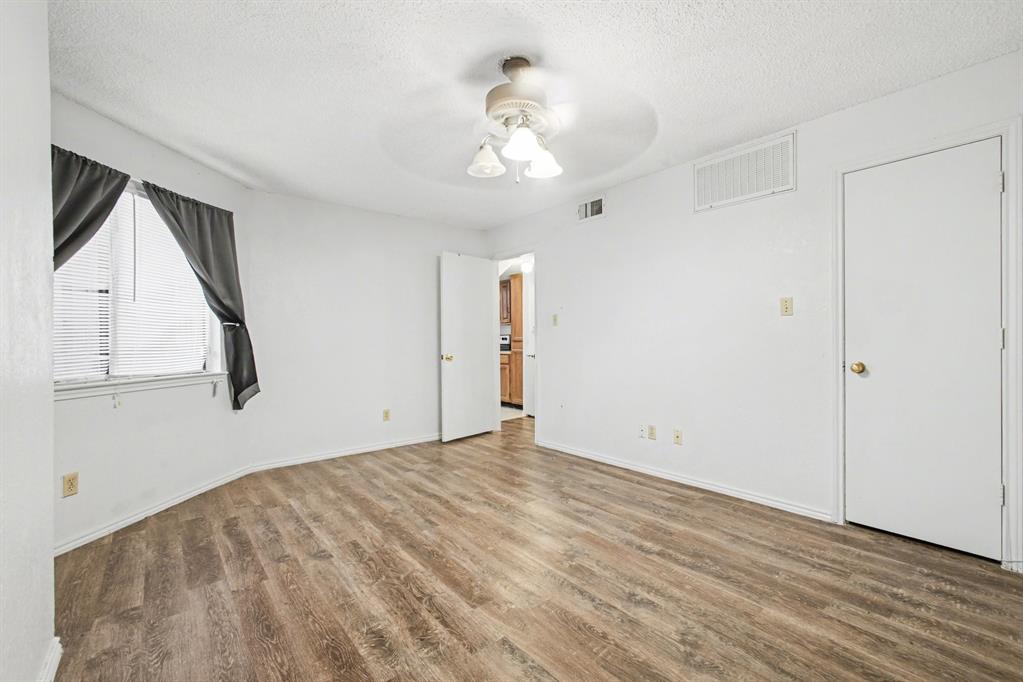 9827 Walnut Street, Unit 210 Dallas, TX 75243 - Photo 27 of 30 a view of an empty room with wooden floor and a window