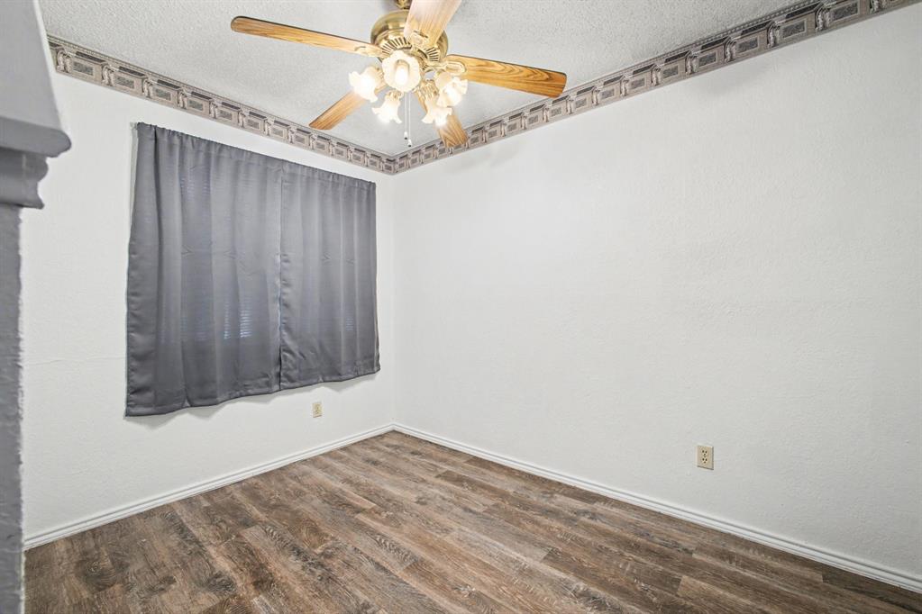 9827 Walnut Street, Unit 210 Dallas, TX 75243 - Photo 9 of 30 en empty room with wooden floor and fan