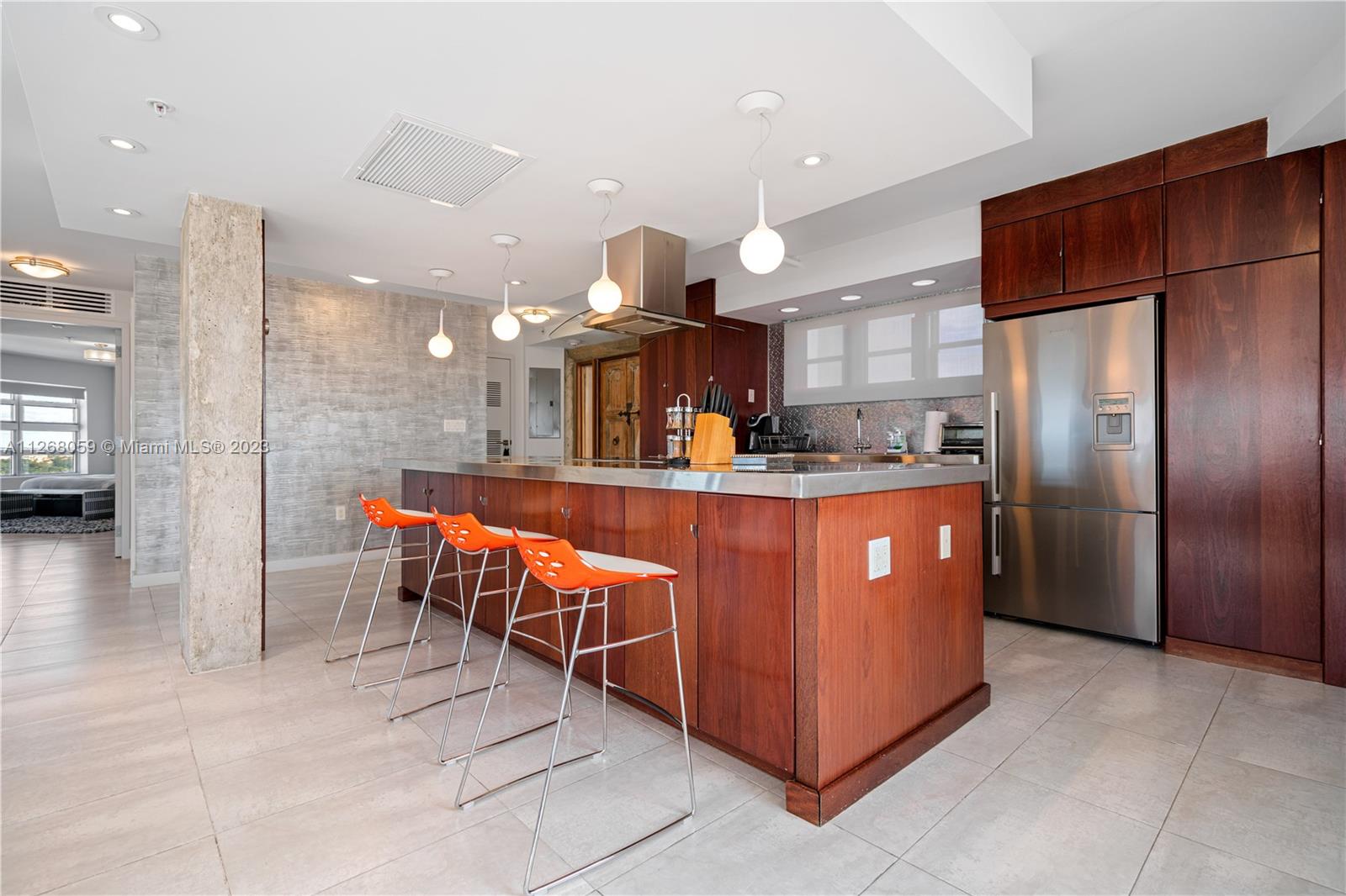 a kitchen with stainless steel appliances granite countertop a table chairs a sink and a refrigerator