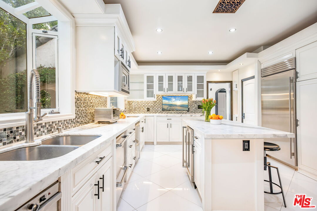 607 North Hillcrest Road Beverly Hills, CA 90210 - Photo 5 of 16 a kitchen with counter top space a sink and cabinets