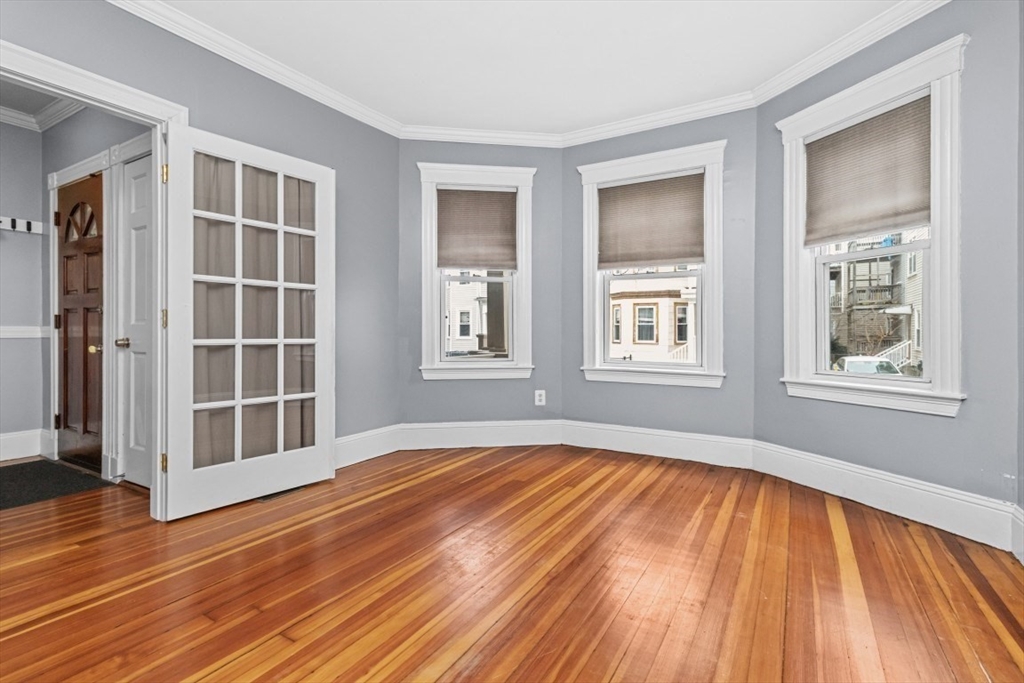 8 Taft Street, Unit 1 Boston, MA 02125 - Photo 19 of 25 a view of an empty room with wooden floor and window
