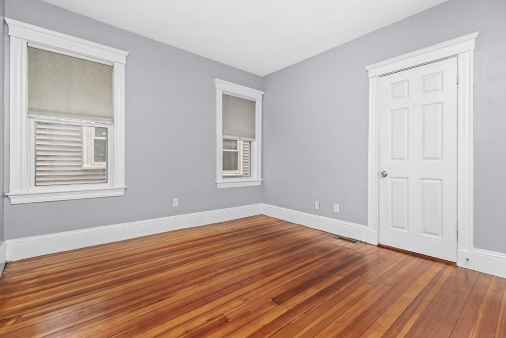 8 Taft Street, Unit 1 Boston, MA 02125 - Photo 21 of 25 a view of an empty room with wooden floor and a window