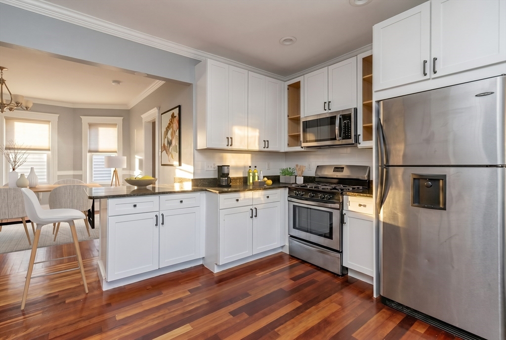 8 Taft Street, Unit 1 Boston, MA 02125 - Photo 5 of 25 a kitchen with granite countertop white cabinets and stainless steel appliances