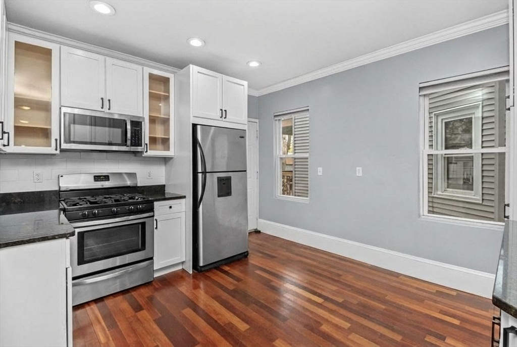 8 Taft Street, Unit 1 Boston, MA 02125 - Photo 9 of 25 a kitchen with stainless steel appliances granite countertop a stove a refrigerator and a microwave