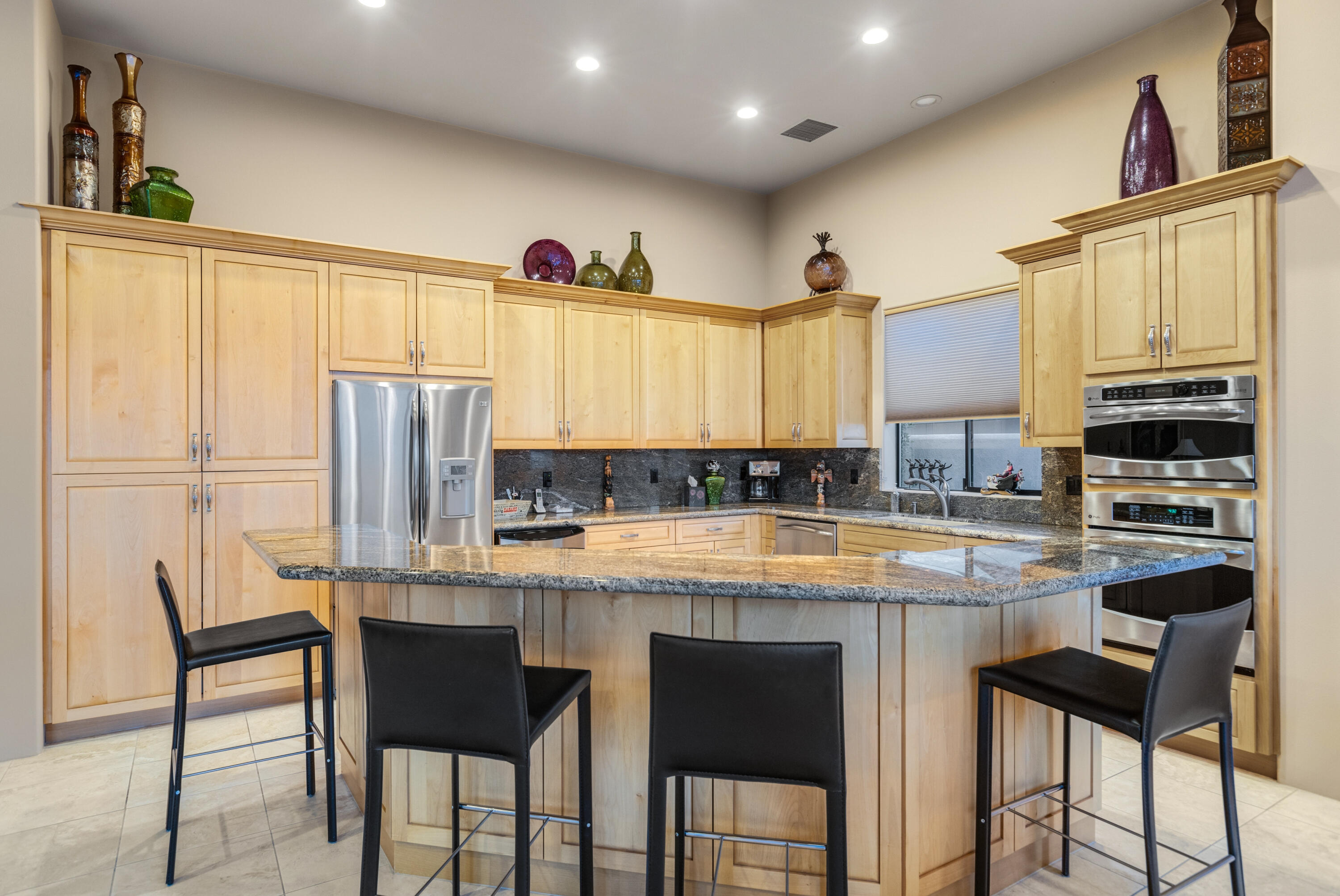 7 Nebulae Way Rancho Mirage, CA 92270 - Photo 14 of 40 a kitchen with stainless steel appliances kitchen island granite countertop a table chairs and a refrigerator