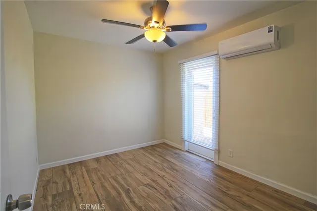 an empty room with closet and a ceiling fan