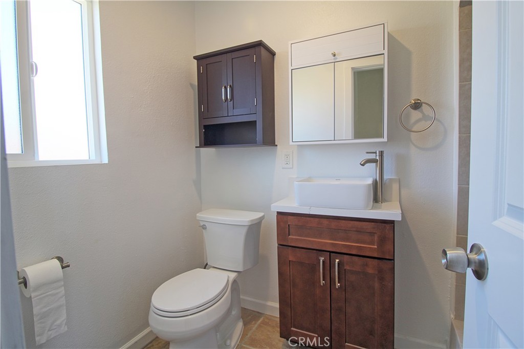 719 East Ramsey Street, Unit 3 Banning, CA 92220 - Photo 7 of 7 a bathroom with a toilet a sink and mirror