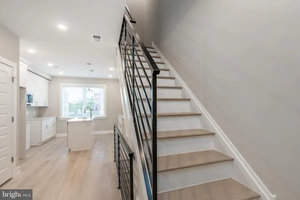 a view of entryway and kitchen with wooden floor