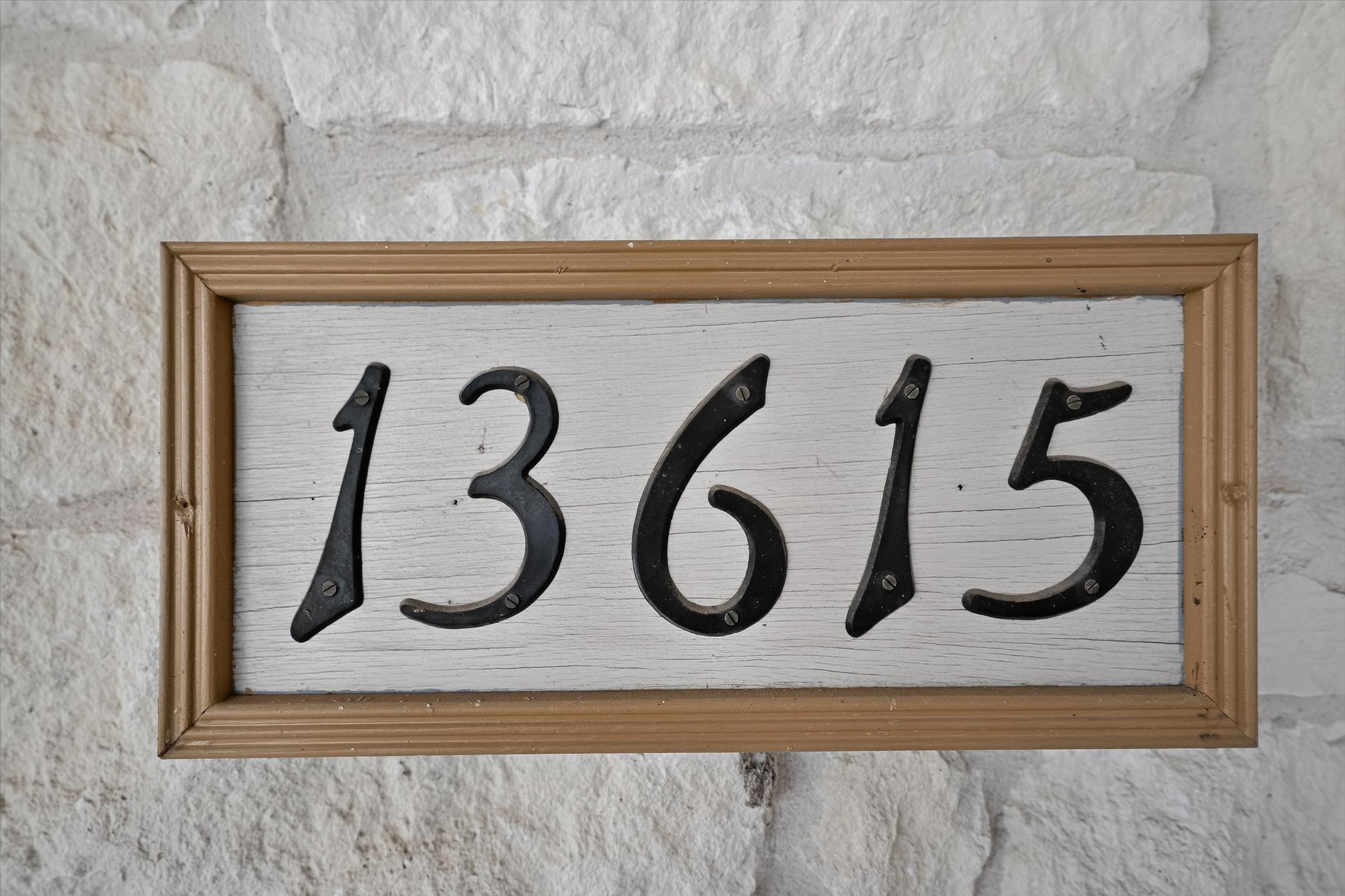 13615 Copperleaf Trail Manchaca, TX 78652 - Photo 9 of 38 Bold black house numbers framed in wood, set against a rugged stone facade.