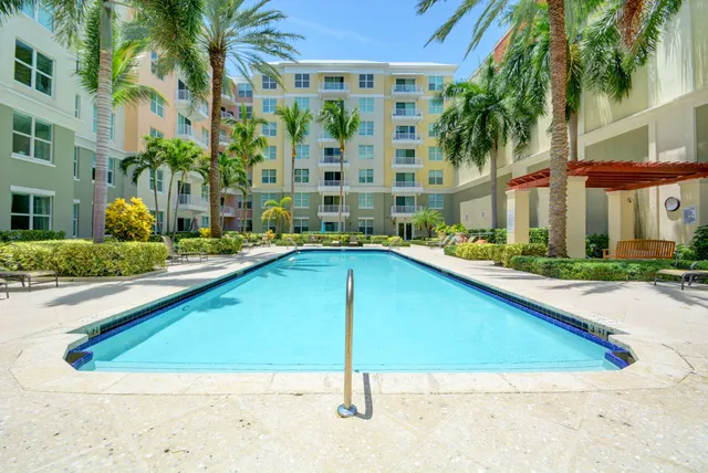 a view of swimming pool with outdoor seating and house in the background