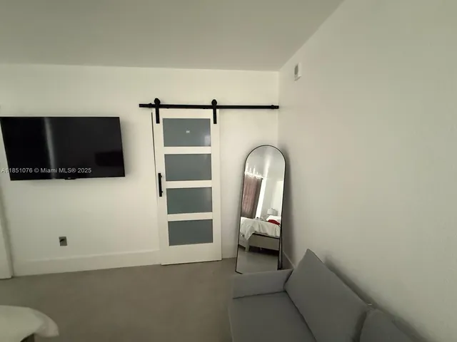 a bedroom with a bed and a flat tv screen