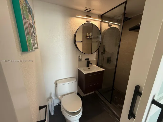 a bathroom with a sink mirror and toilet