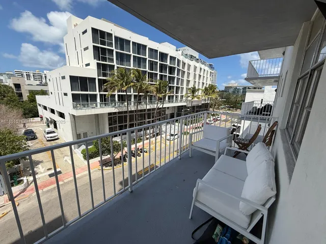 a view of a balcony with chairs and a potted plant