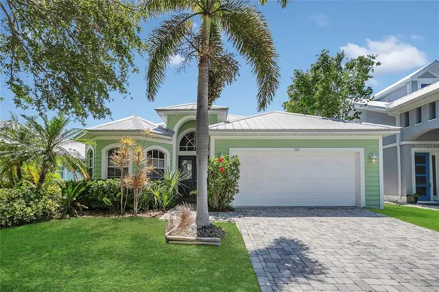 a front view of a house with a garden and plants