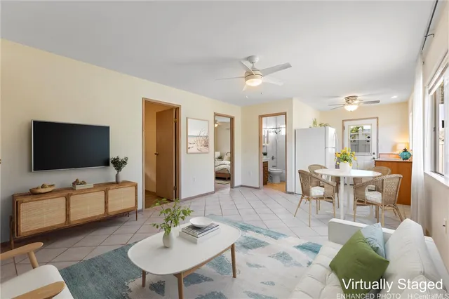 a living room with furniture a flat screen tv and kitchen view