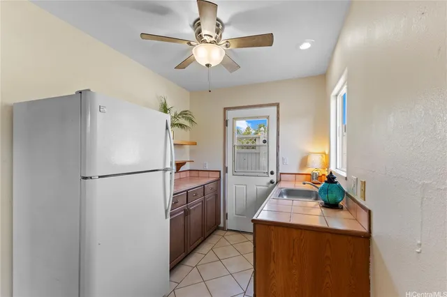 a kitchen with stainless steel appliances granite countertop a refrigerator a sink a stove and a refrigerator