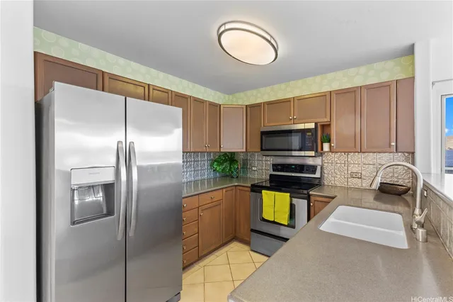 a kitchen with stainless steel appliances granite countertop a refrigerator a stove and a sink with wooden floor